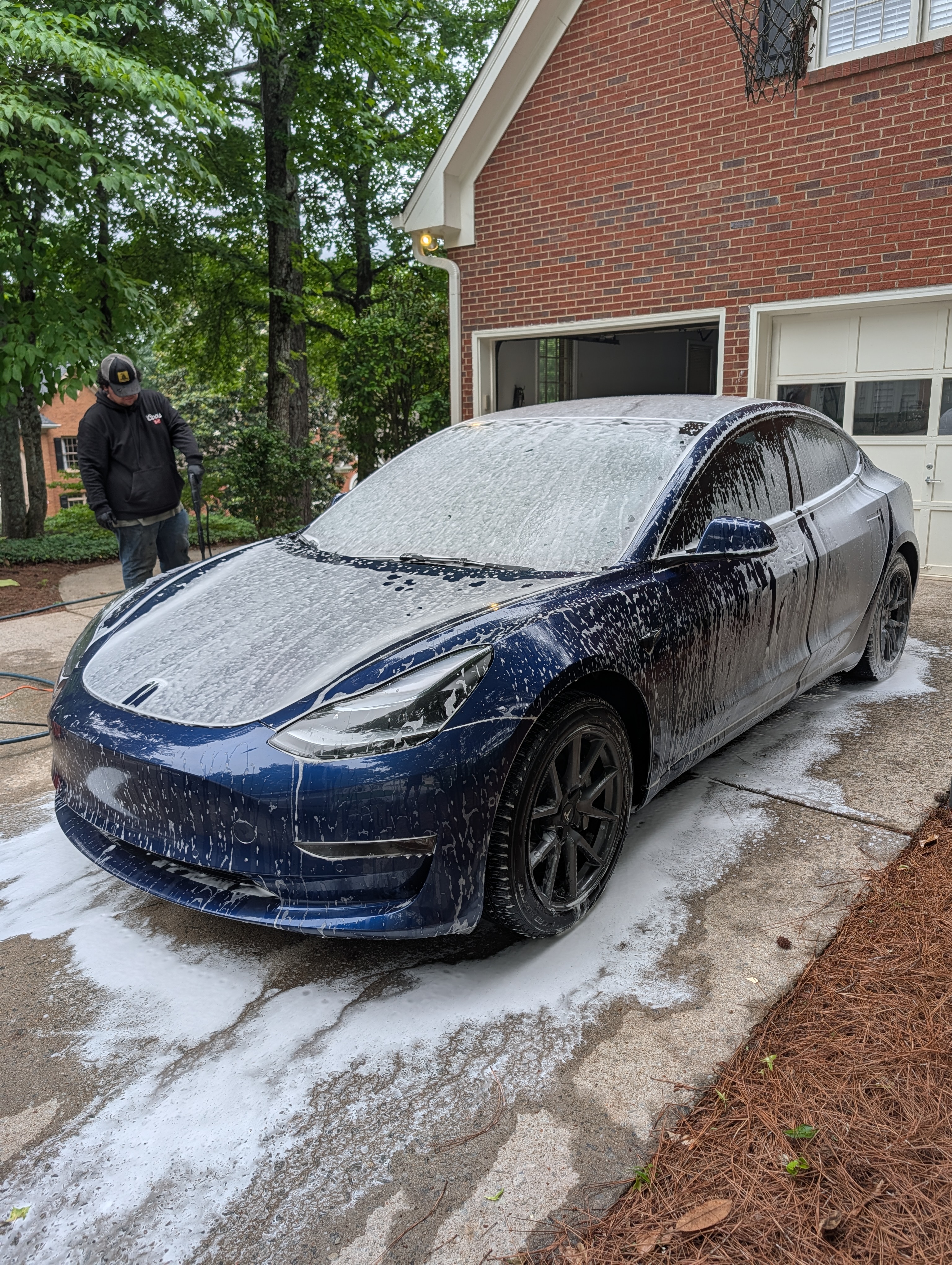 Countryside Auto Detailing team performing interior foam detailing on a Tesla Model 3 with professional-grade equipment